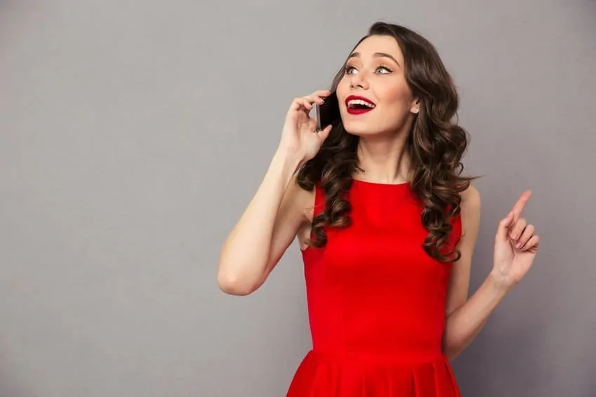Happy woman in red dress talking on the phone Frau anrufen Frau am Smartphone